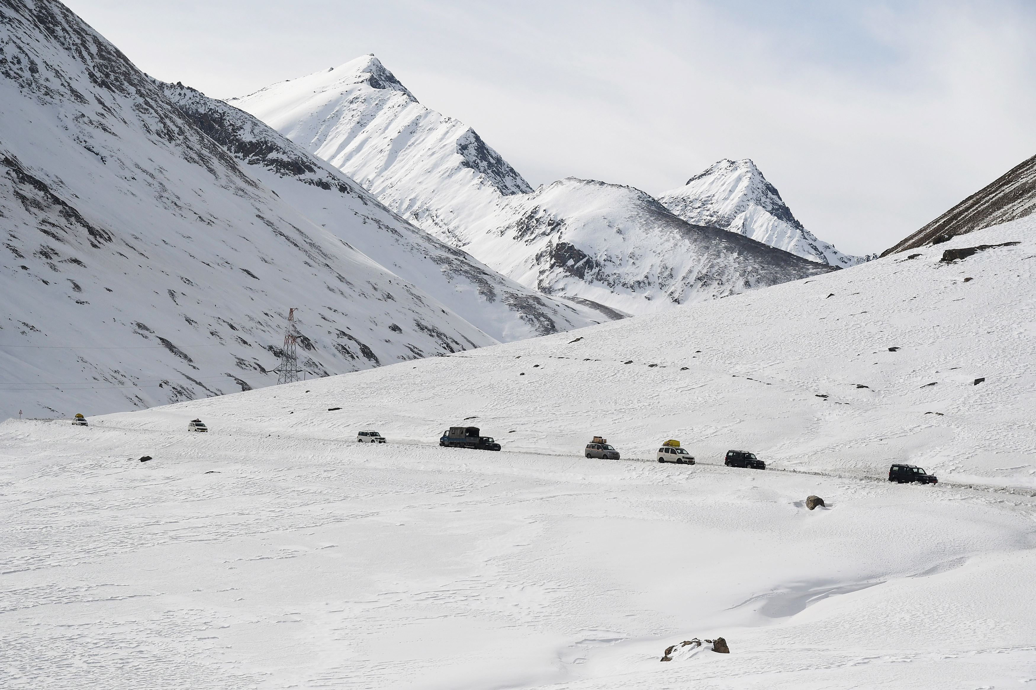 Vehicles move through the snow-covered mountains on Srinagar-Leh Highway at Zojila Pass