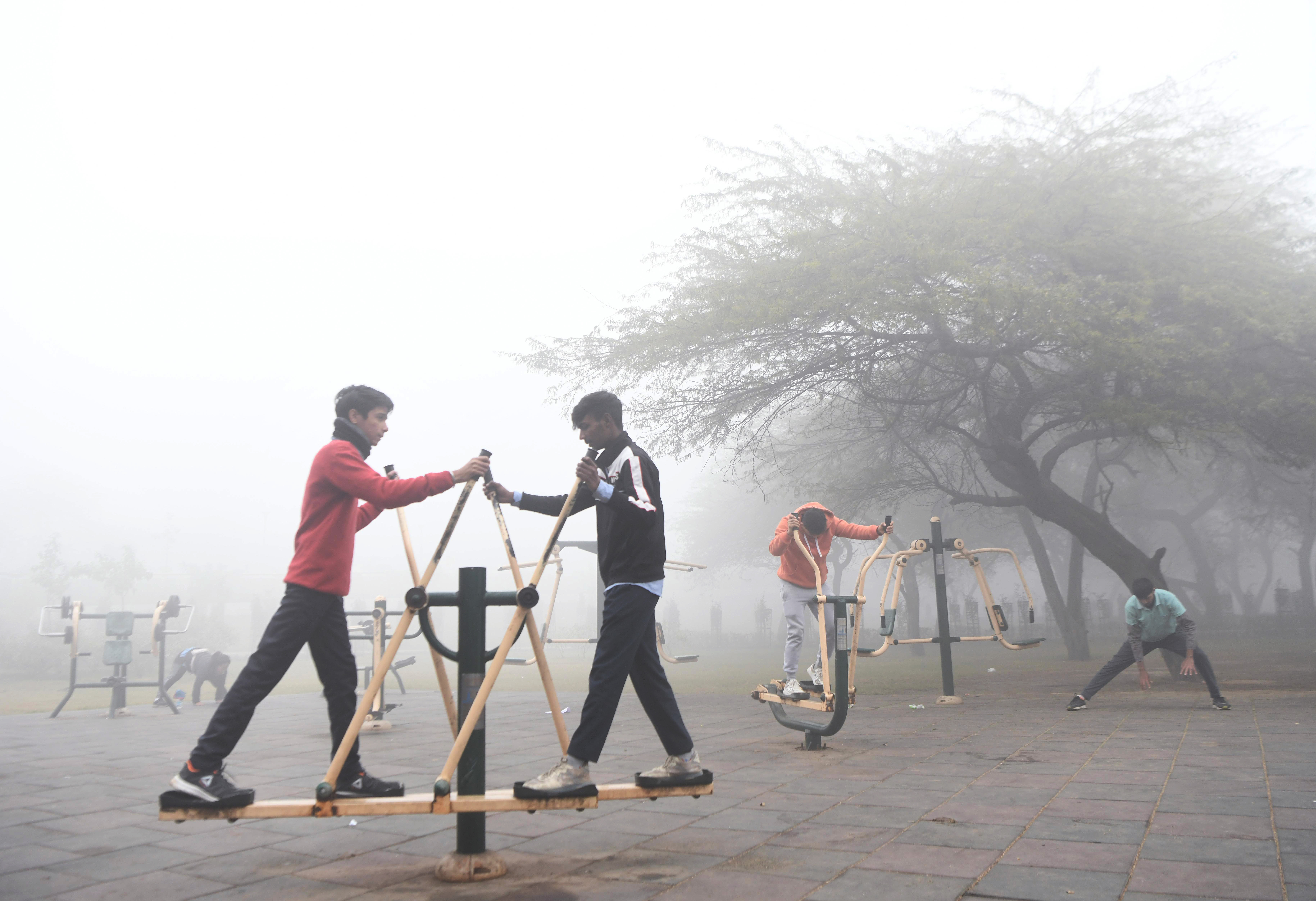 People doing exercise in a park amid dense fog