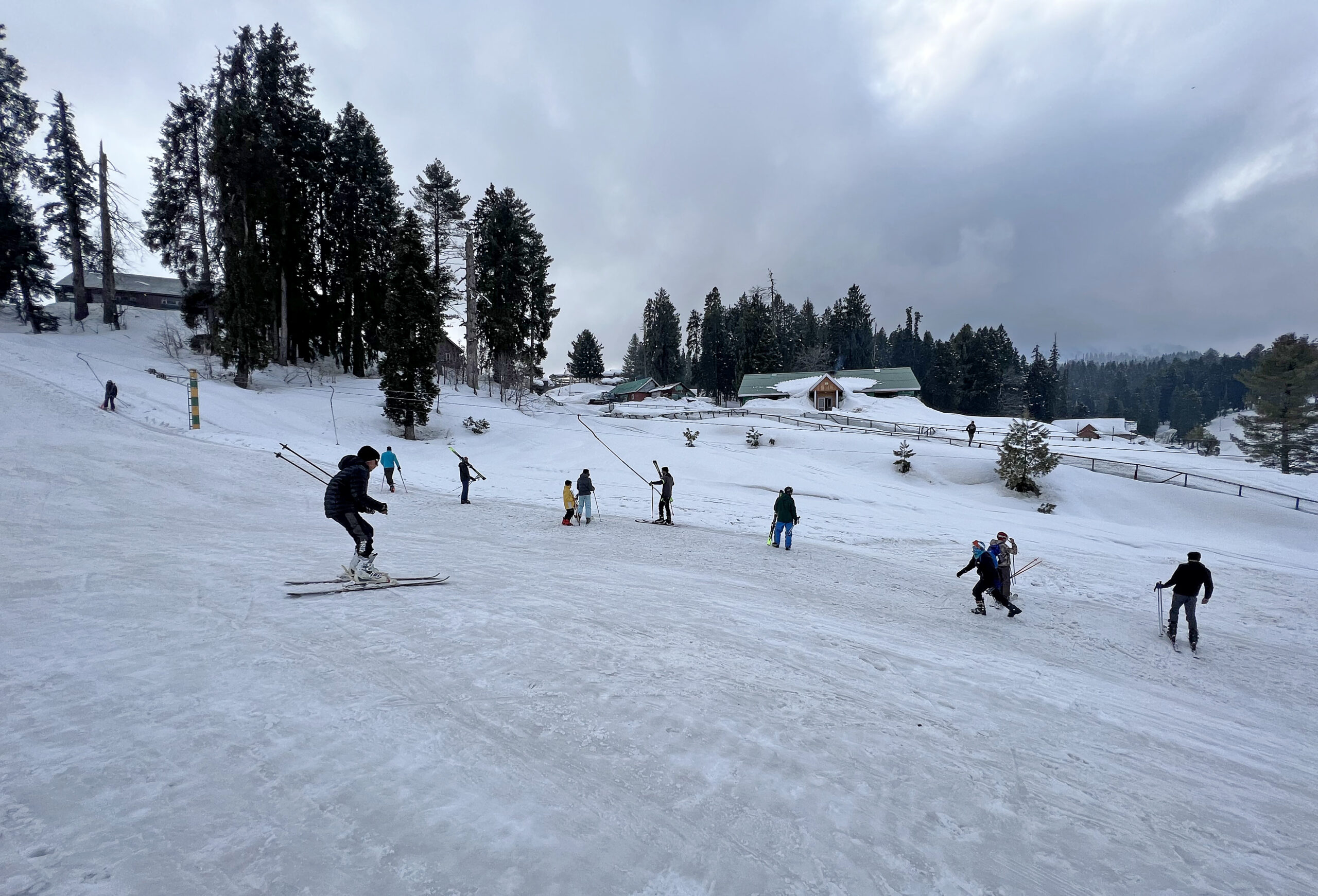 Tourists enjoy skiing on the snow-covered area of the Gulmarg Ski resort