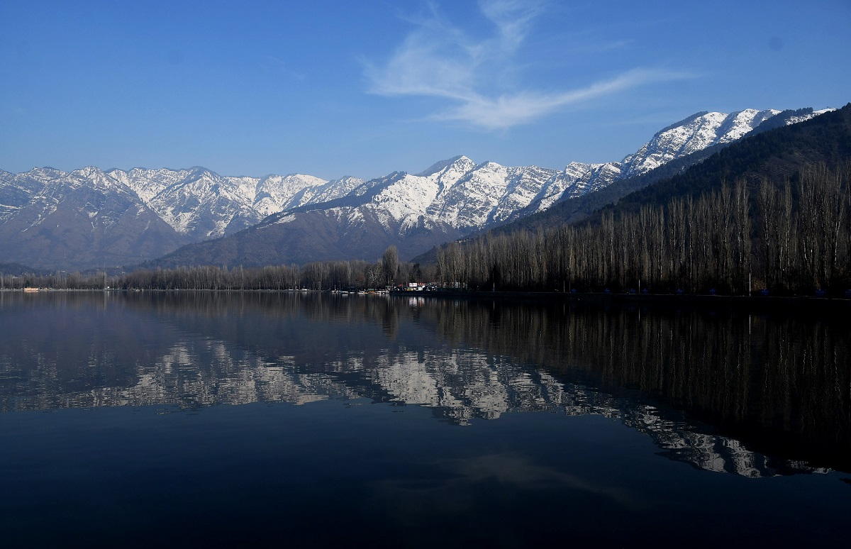 A scenic view of snow-covered mountains behind the Dal lake in Srinagar ...