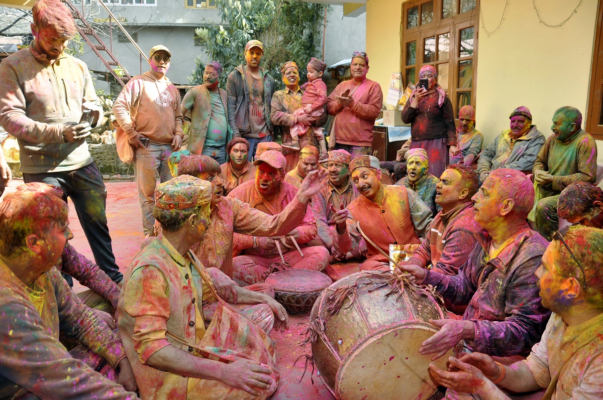 People play musical instrument during the Holi celebrations