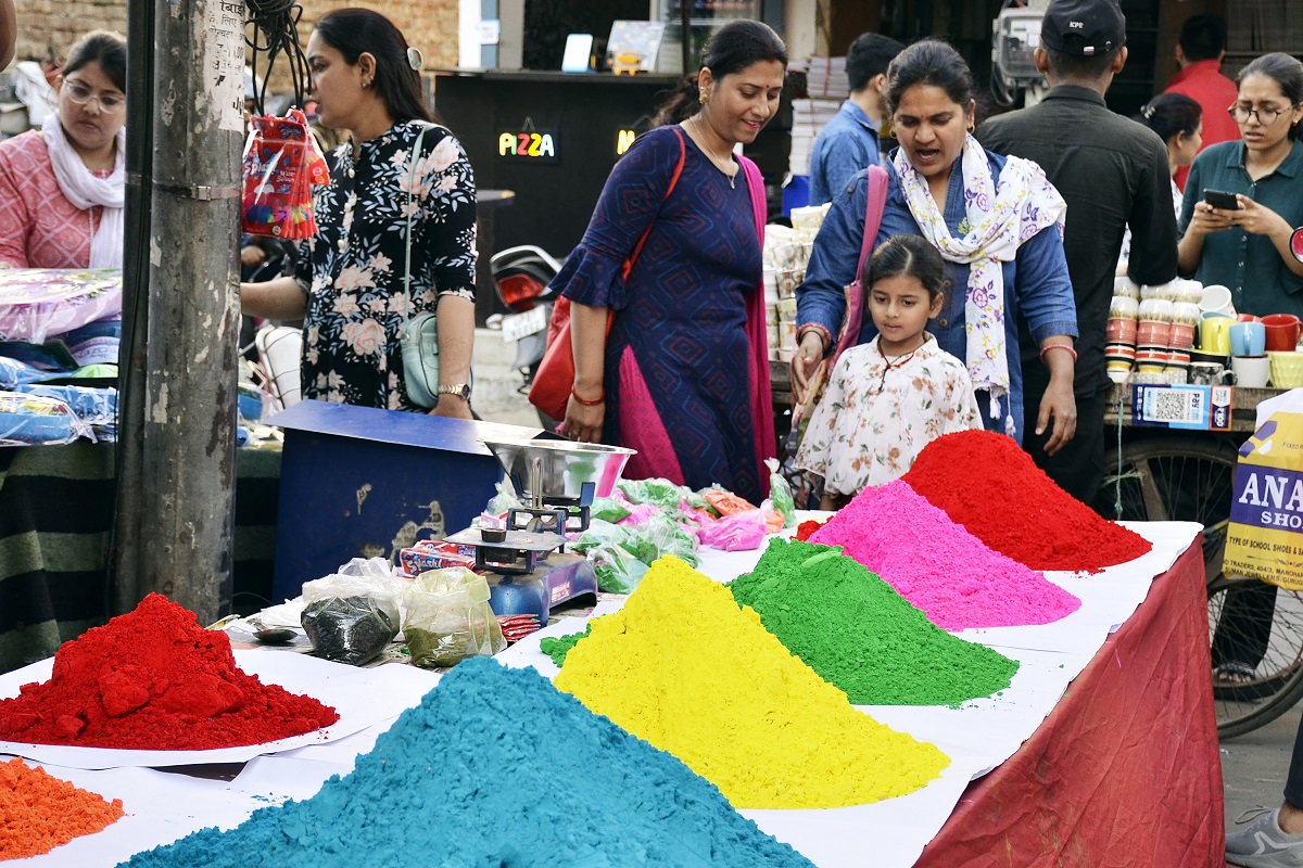 People shop for powder colours (Gulaal) for the upcoming Holi festival