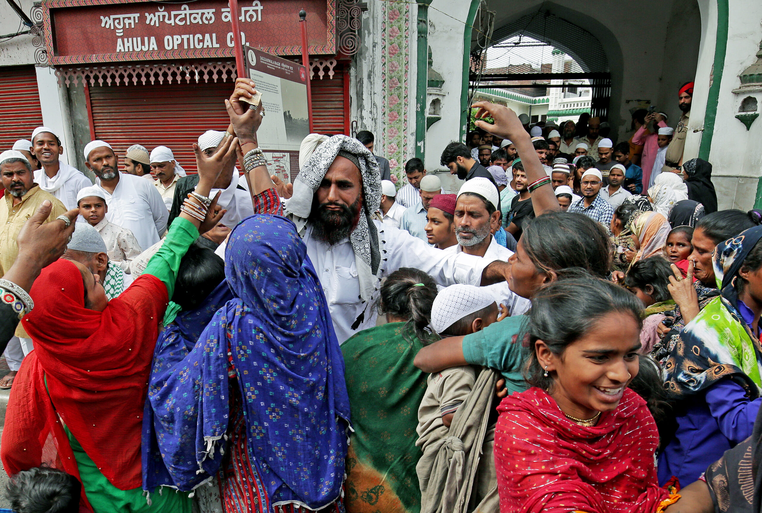 Alms seekers rush to get alms from a devotee as he comes out after Namaz on the occasion of Eid-ul-Fitr