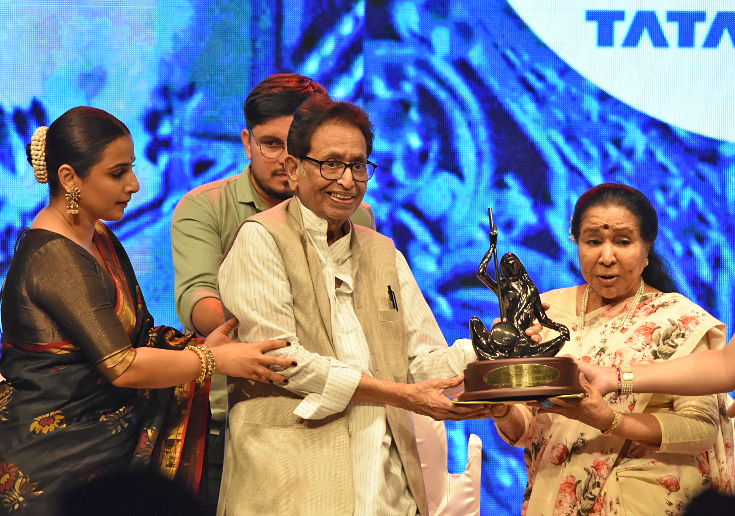 Vidya Balan and Lata Mangeshkar’s brother Hridaynath Mangeshkar hand over an award to Asha Bhosle.