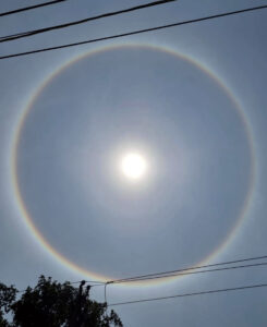 A mysterious rainbow ring envelopes the sun in the sky, in Prayagraj.