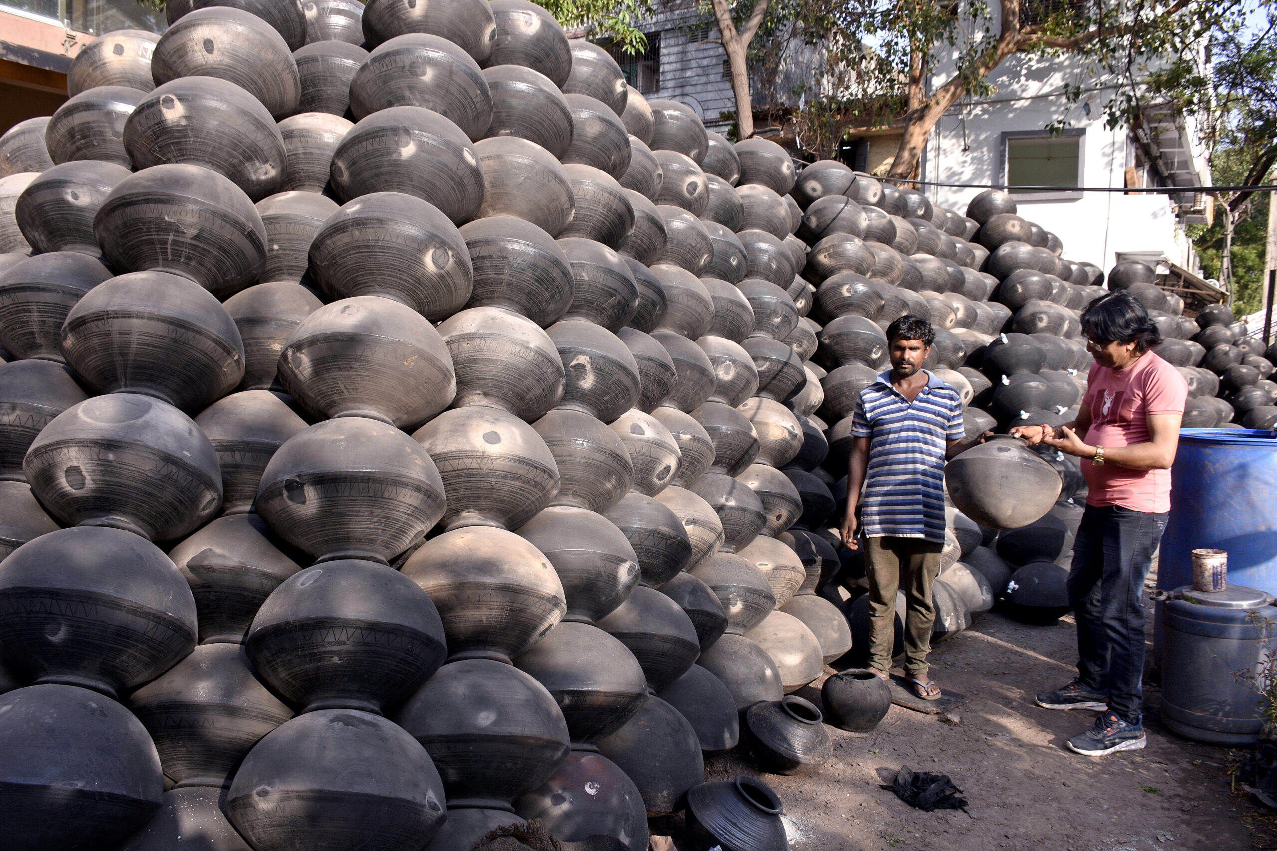 A man shops for earthen pots during blistering summer