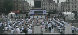 People perform yoga at Trafalgar Square in London