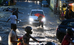 Hyderabad: Amid heavy rainfall commuters wade through waterlogged street 