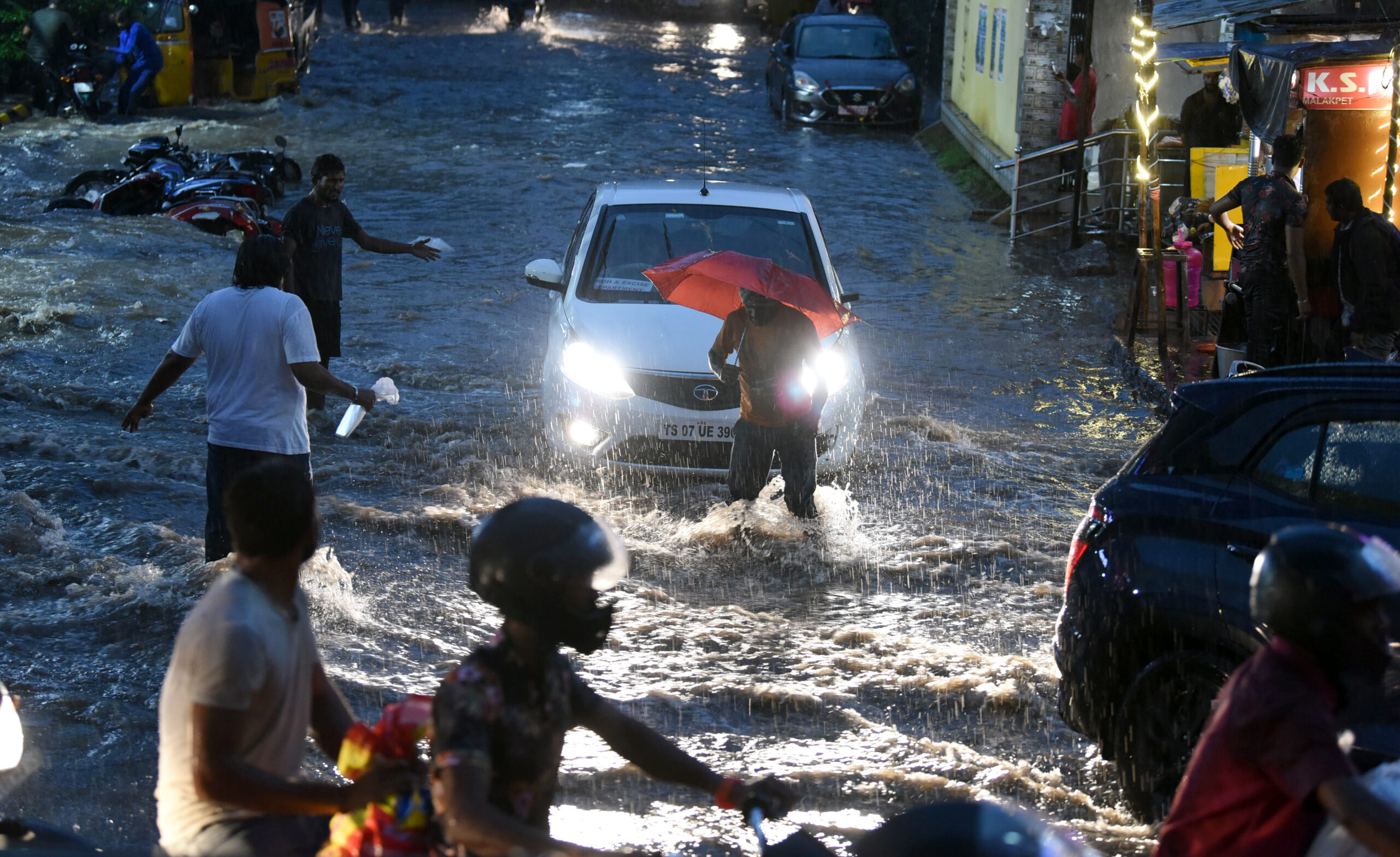 Hyderabad: Amid heavy rainfall commuters wade through waterlogged street 