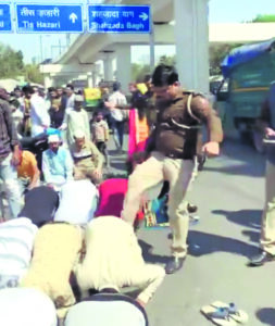 Police officer seen kicking devotees offering Namaz