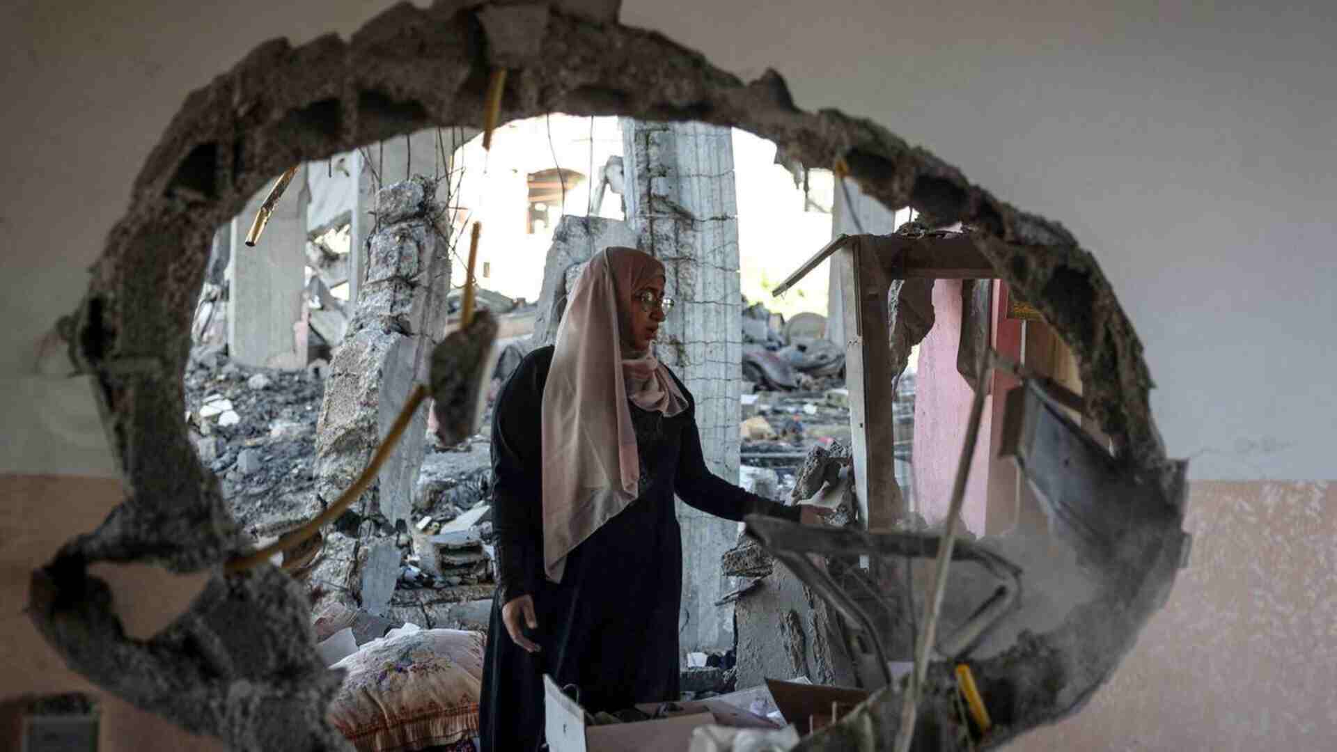 Aftermath of an Israeli Airstrike where a woman checks on the rubble in Rafah