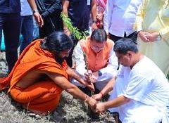 Uttarakhand CM Dhami plants sapling with Baba Ramdev at Dhanvantari Dham on Harela